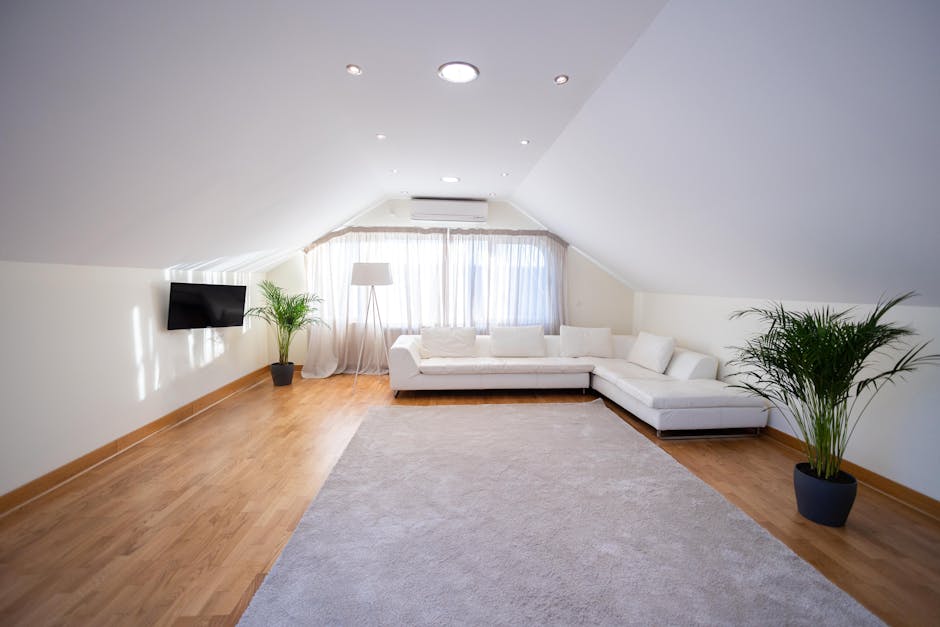 A bright, spacious living room featuring a soft beige carpet that appears clean and well-maintained, with walls painted in a light yellow shade and decorative white trim. Multiple large windows with p